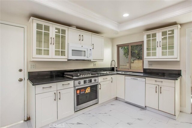 kitchen with a raised ceiling, sink, crown molding, stainless steel appliances, and white cabinets