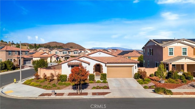 view of front of home featuring solar panels, a garage, and a mountain view