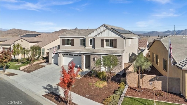 view of front facade featuring a garage, a mountain view, and solar panels