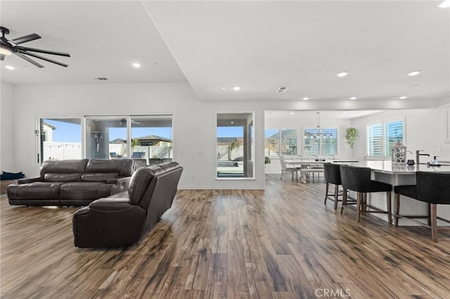 living room featuring wood-type flooring and ceiling fan