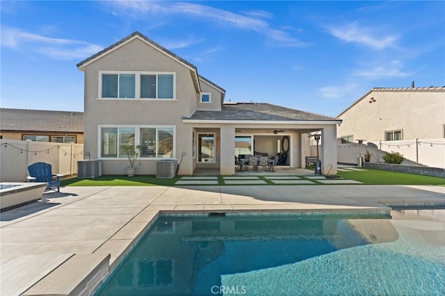 rear view of property with ceiling fan, a patio, cooling unit, and a fenced in pool