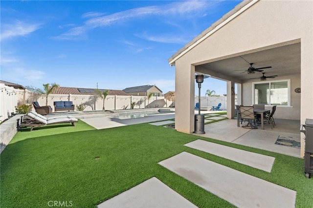 view of yard featuring a patio area, ceiling fan, and a fenced in pool