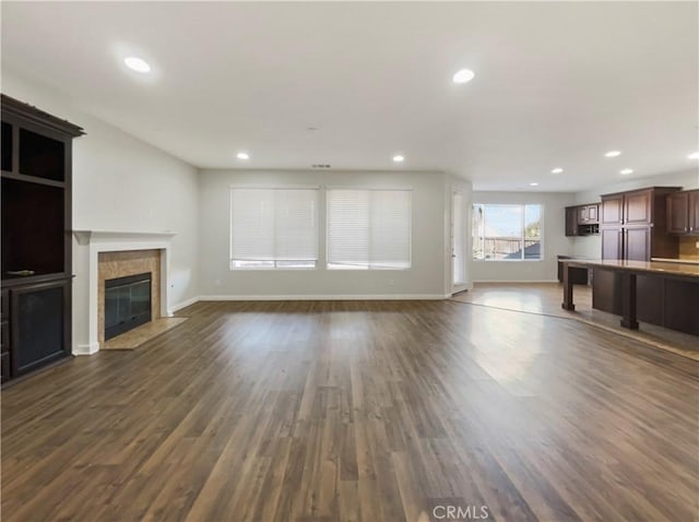 unfurnished living room with dark hardwood / wood-style flooring and a fireplace