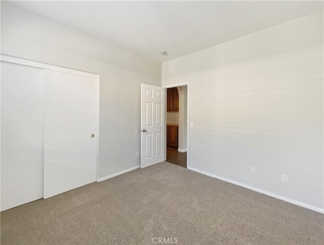 unfurnished bedroom featuring carpet flooring and a closet