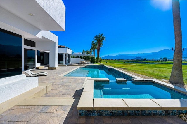 view of swimming pool featuring a mountain view, a patio area, and an in ground hot tub