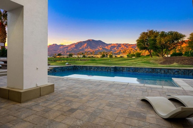 pool at dusk featuring a mountain view