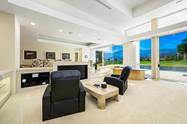 living room with a raised ceiling and light colored carpet