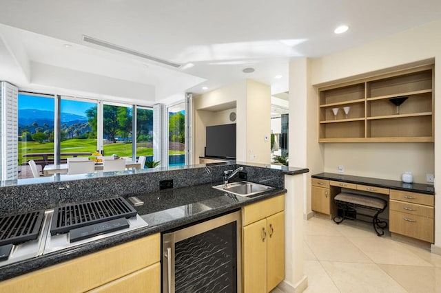 kitchen featuring sink, dark stone countertops, light tile patterned floors, light brown cabinetry, and beverage cooler