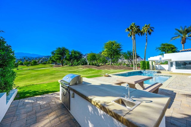 view of patio / terrace featuring a mountain view, area for grilling, and sink