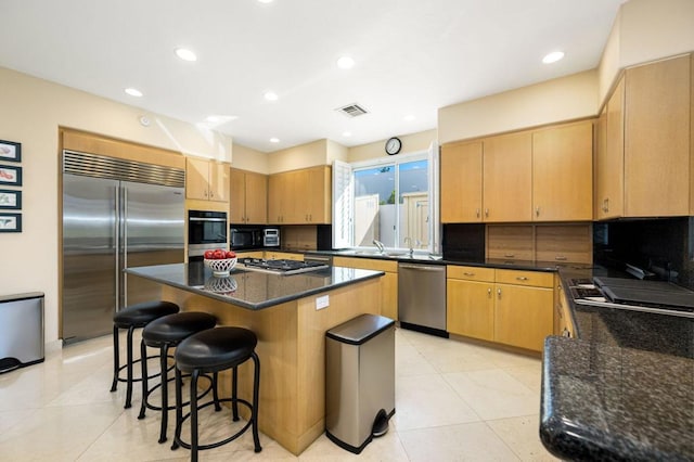 kitchen with backsplash, a center island, light tile patterned flooring, and stainless steel appliances