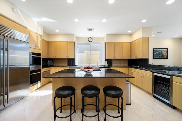 kitchen with a kitchen island, stainless steel built in refrigerator, and light brown cabinetry