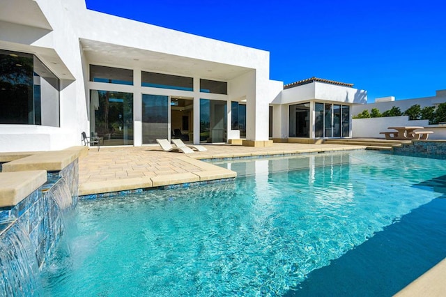 view of swimming pool featuring pool water feature and a patio