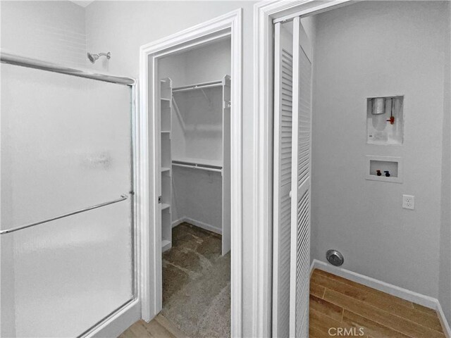 bathroom with hardwood / wood-style floors and a shower with shower door