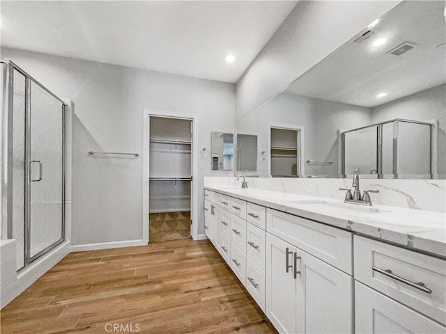 bathroom featuring hardwood / wood-style flooring, vanity, and a shower with shower door