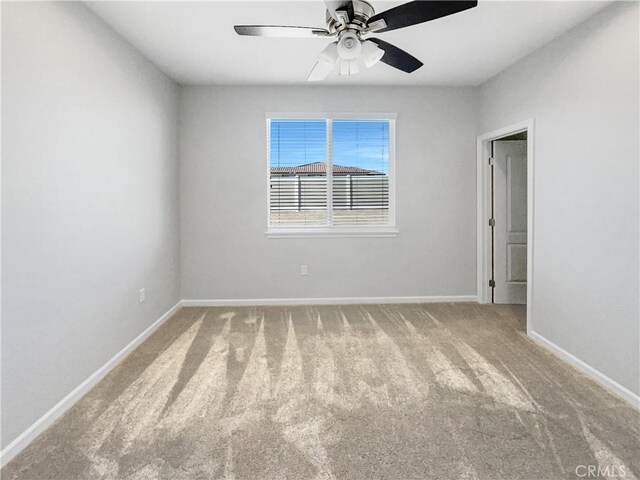 carpeted spare room with ceiling fan