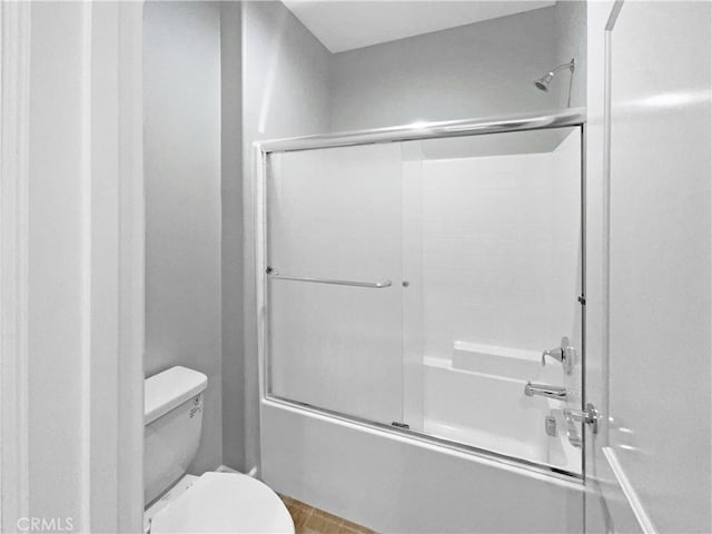 bathroom with shower / bath combination with glass door and toilet