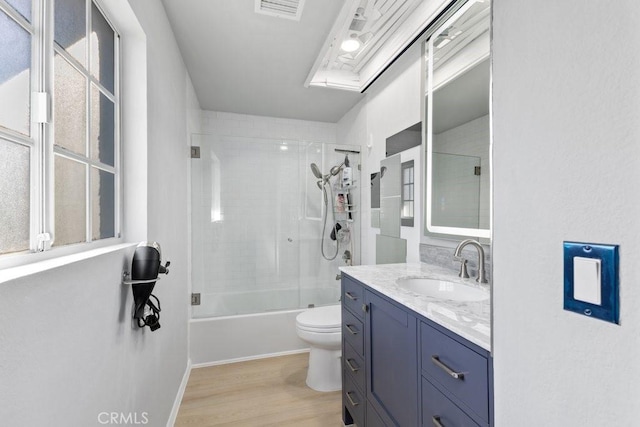 full bathroom featuring combined bath / shower with glass door, vanity, wood-type flooring, and toilet