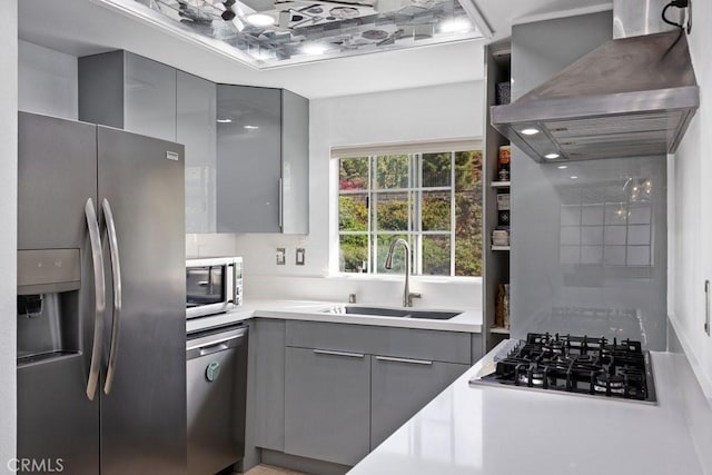 kitchen with stainless steel appliances, gray cabinetry, extractor fan, and sink