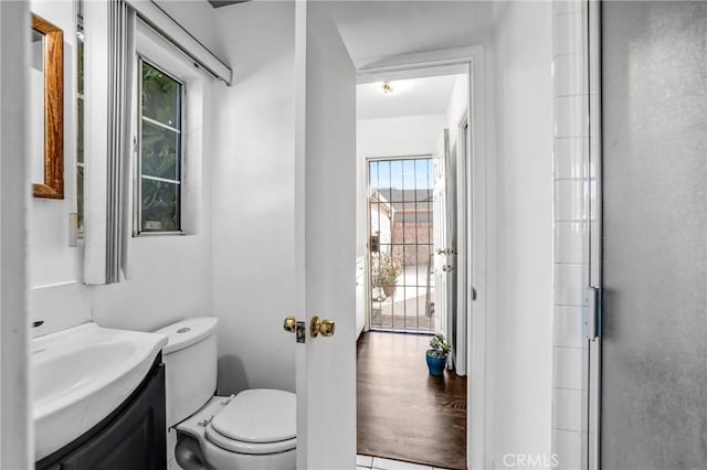 bathroom featuring hardwood / wood-style flooring, vanity, toilet, and walk in shower