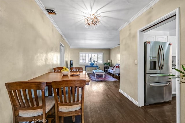 dining area with dark hardwood / wood-style floors, crown molding, and a notable chandelier