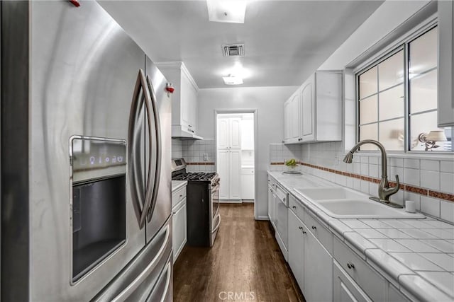 kitchen with sink, dark wood-type flooring, backsplash, white cabinets, and appliances with stainless steel finishes