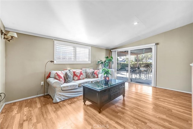 living room with light hardwood / wood-style flooring and vaulted ceiling