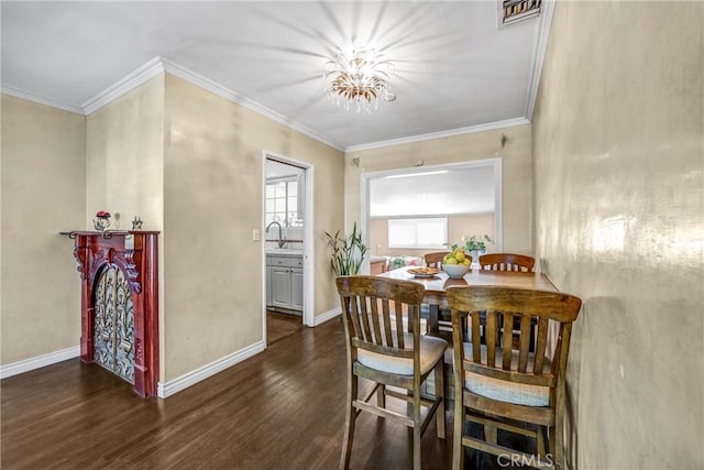 dining room featuring dark hardwood / wood-style flooring, crown molding, and an inviting chandelier