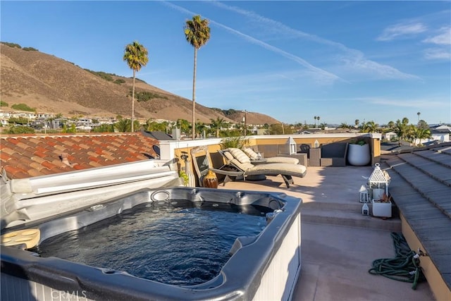 view of patio / terrace featuring a hot tub and a mountain view