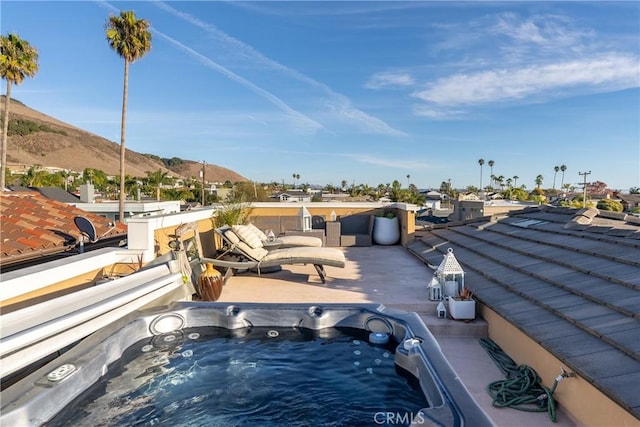 view of swimming pool featuring an outdoor hot tub and a mountain view