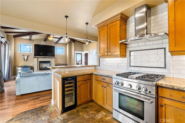 kitchen with beverage cooler, wall chimney exhaust hood, high end stove, and tasteful backsplash