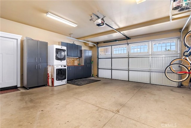 garage featuring a garage door opener and stacked washer / drying machine