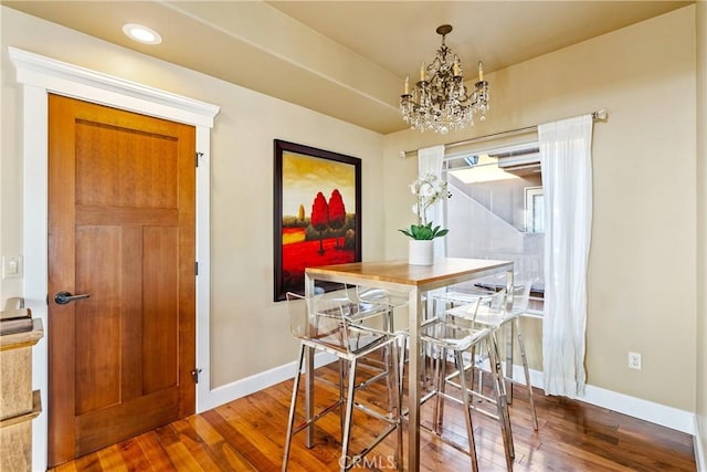 dining space featuring hardwood / wood-style floors and a chandelier