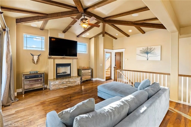 living room with hardwood / wood-style floors, a healthy amount of sunlight, and a stone fireplace