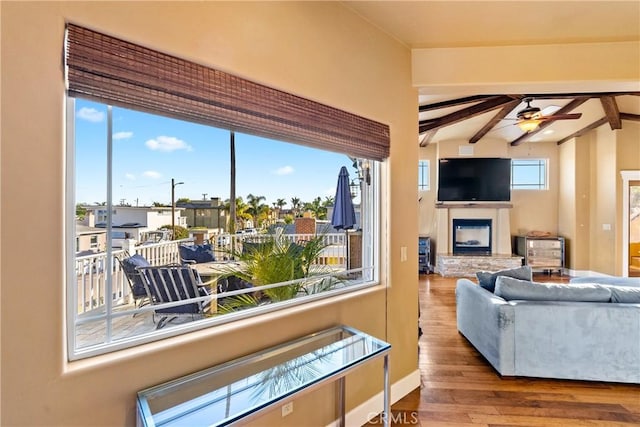 living room featuring a wealth of natural light, ceiling fan, vaulted ceiling with beams, and hardwood / wood-style flooring