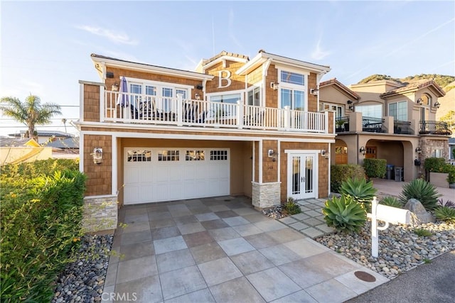 view of front facade with french doors, a balcony, and a garage