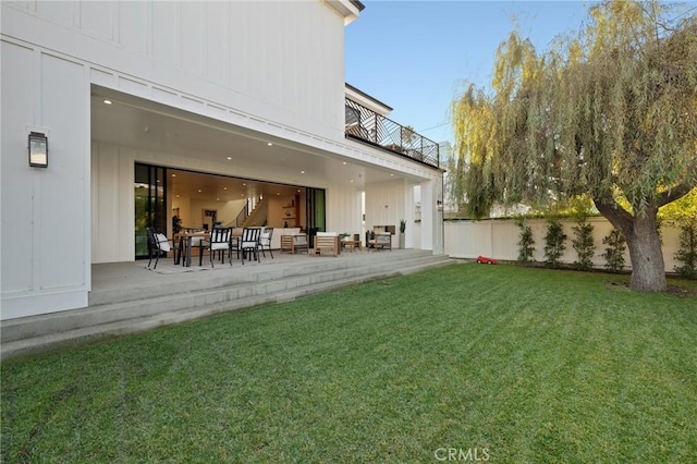 view of yard featuring a balcony, a patio, and an outdoor hangout area