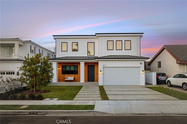 modern inspired farmhouse with a yard, a porch, and a garage