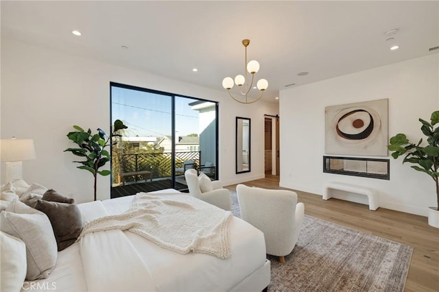 bedroom with access to outside, light hardwood / wood-style flooring, and a notable chandelier