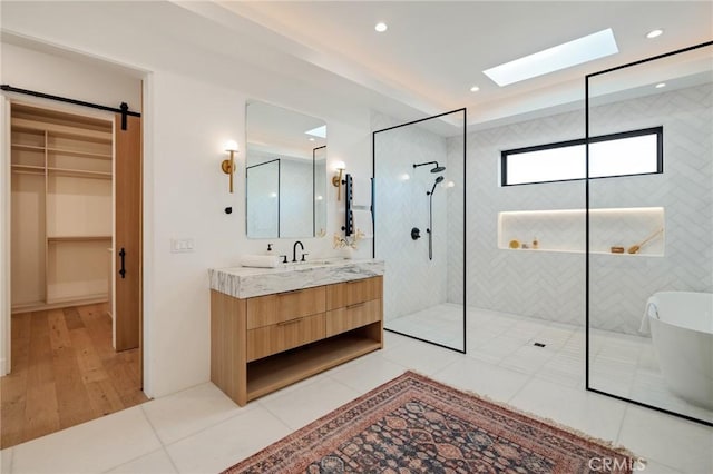 bathroom featuring a tile shower, vanity, and wood-type flooring