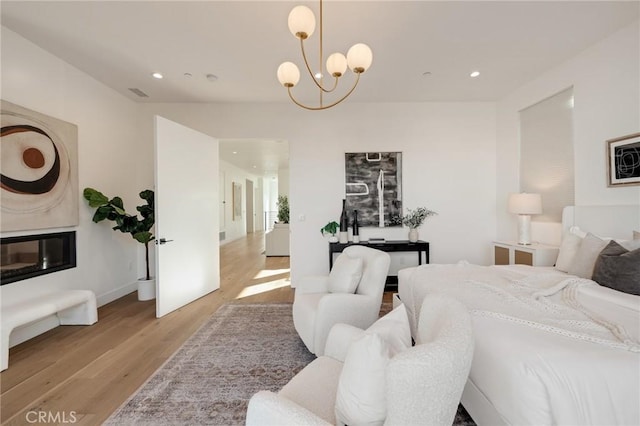 bedroom featuring light wood-type flooring and an inviting chandelier