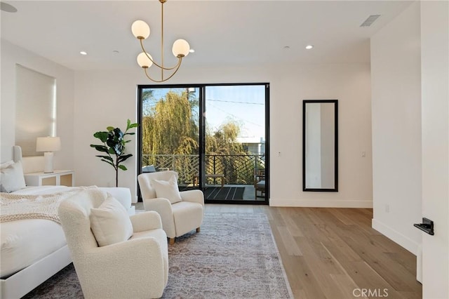 bedroom featuring a notable chandelier, access to exterior, and light wood-type flooring