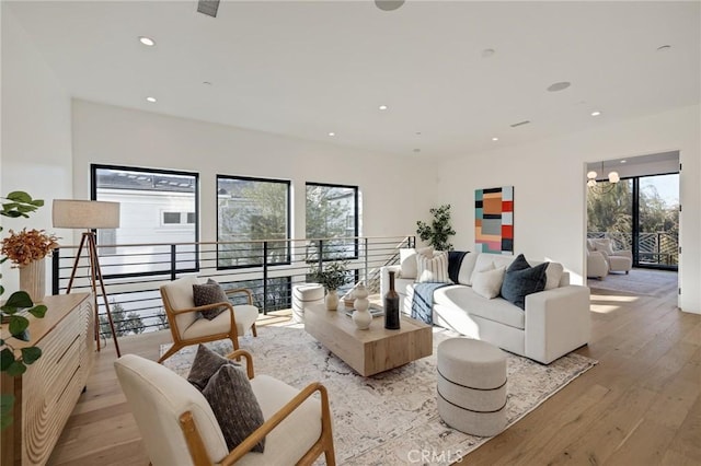 living room with an inviting chandelier and light hardwood / wood-style flooring