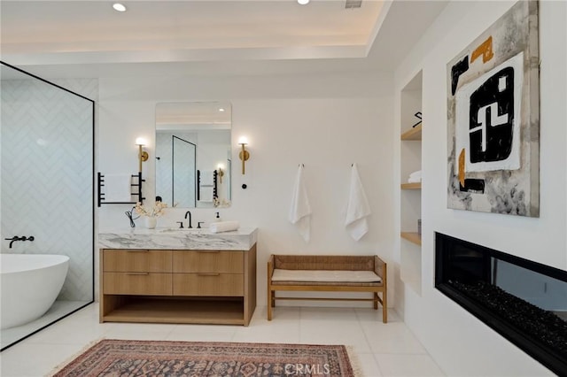 bathroom with built in features, vanity, a tub to relax in, and tile patterned floors