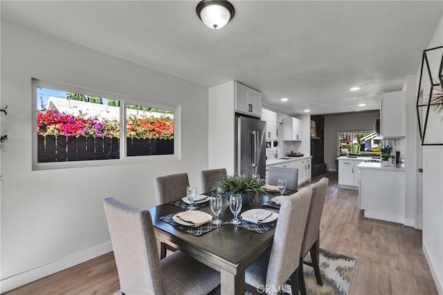 dining area featuring sink and light hardwood / wood-style floors