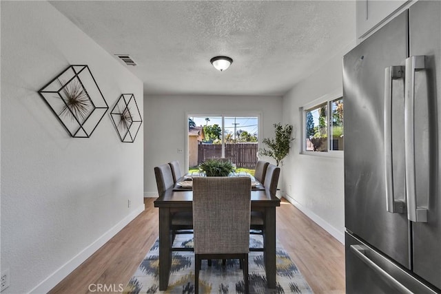 dining space featuring a textured ceiling and hardwood / wood-style floors