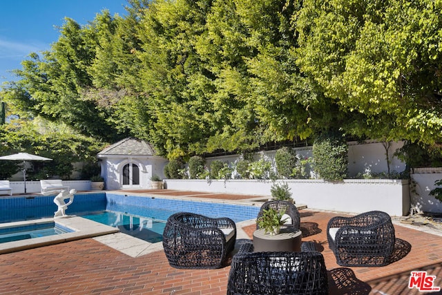 view of pool with an outdoor structure, a patio, and a hot tub