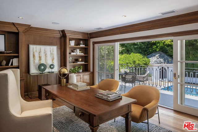 office featuring built in shelves, light hardwood / wood-style floors, and crown molding