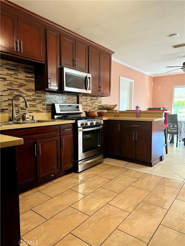 kitchen featuring sink, decorative backsplash, ceiling fan, ornamental molding, and stainless steel appliances