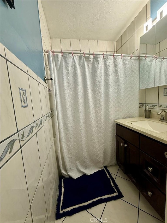 bathroom featuring vanity, backsplash, tile patterned floors, a textured ceiling, and tile walls