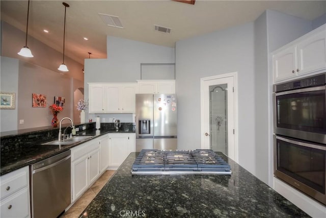 kitchen with white cabinets, lofted ceiling, and appliances with stainless steel finishes